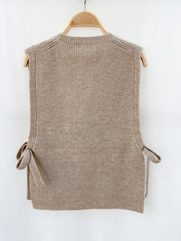 Zachte en comfortabele taupe mouwloze trui met ronde hals en trendy zijstrikken.