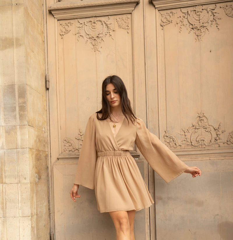 Stijlvolle taupe jurk met V-hals en elastische taille, perfect voor casual en elegante gelegenheden.