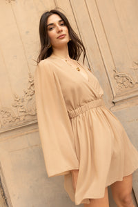Taupe jurk met elastische taille en V-hals, korte lengte en gevoerde onderkant voor extra comfort.