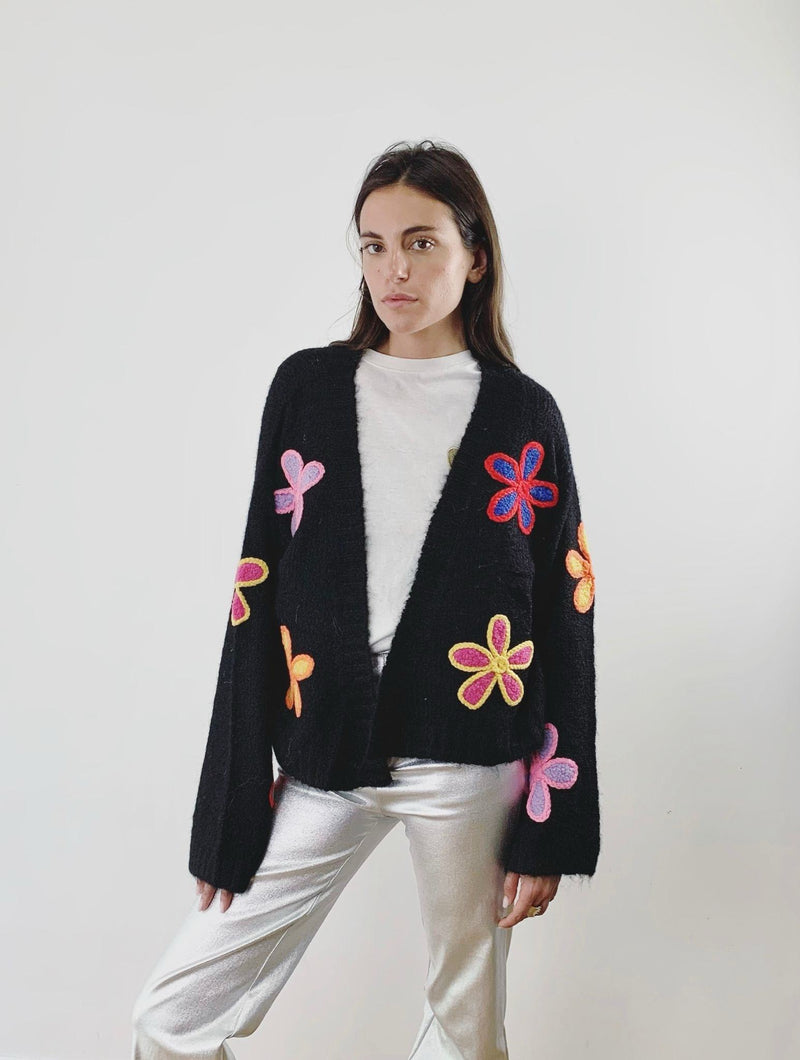 Zwart gebreid vest met kleurrijke bloemen – speels en trendy
